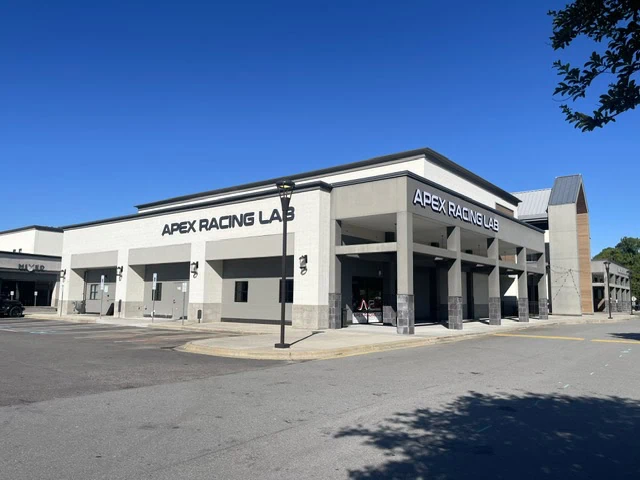 Apex Racing Lab building with a clear blue sky and trees in the background.